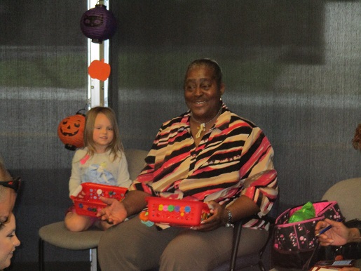 A child is telling a story using her story basket sitting next to Miss Lolita